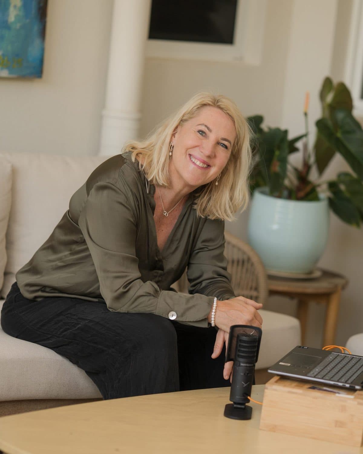 Debbie Thompson smiling beside her microphone and laptop