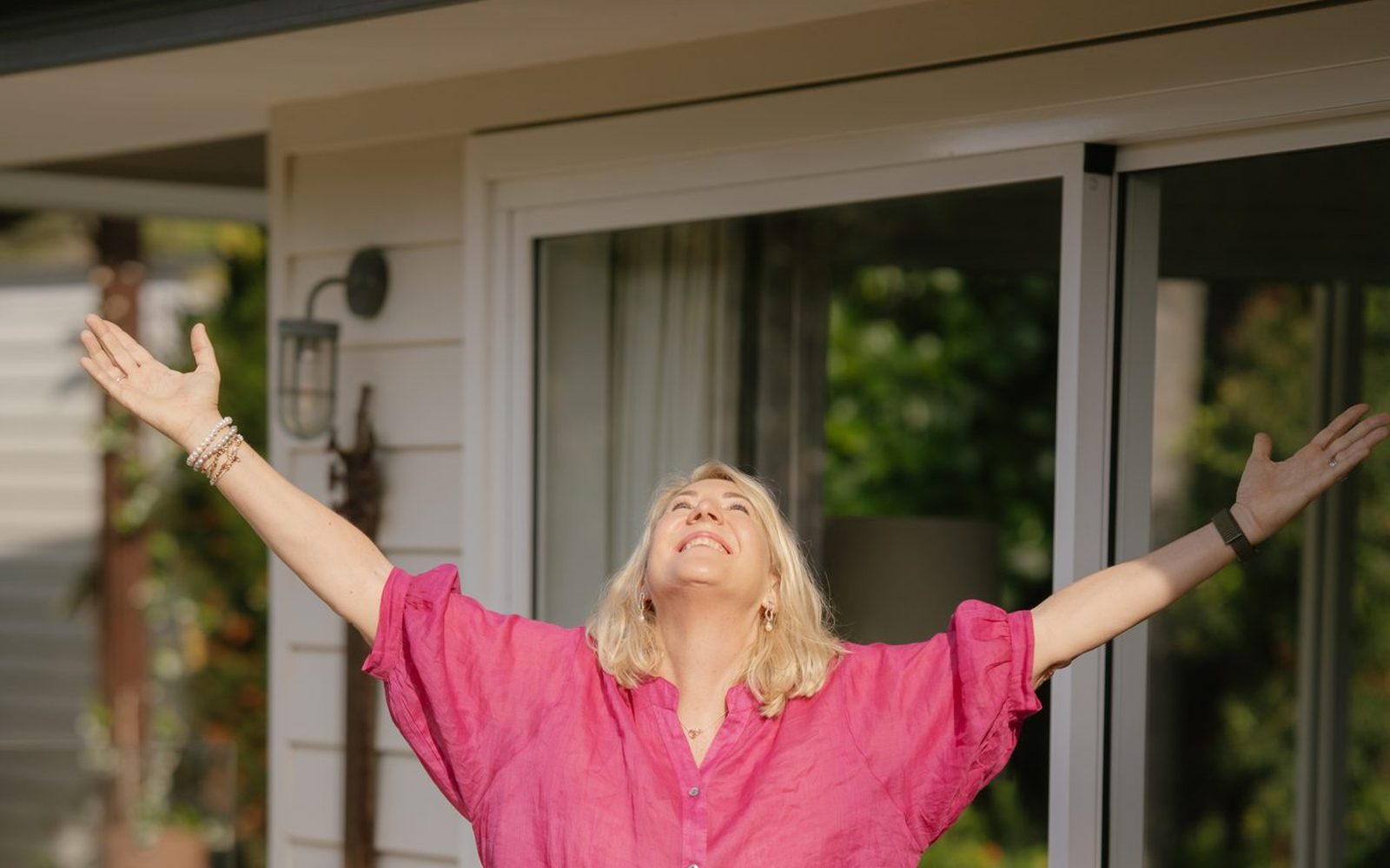 Debbie with her arms open wide, face to the sun
